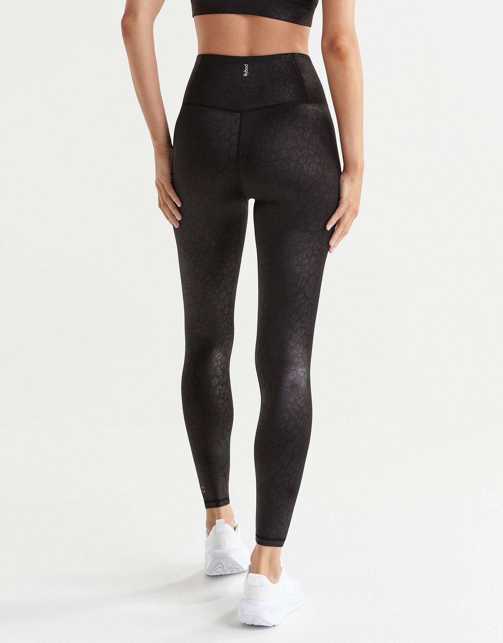 Person wearing black leggings on a white background