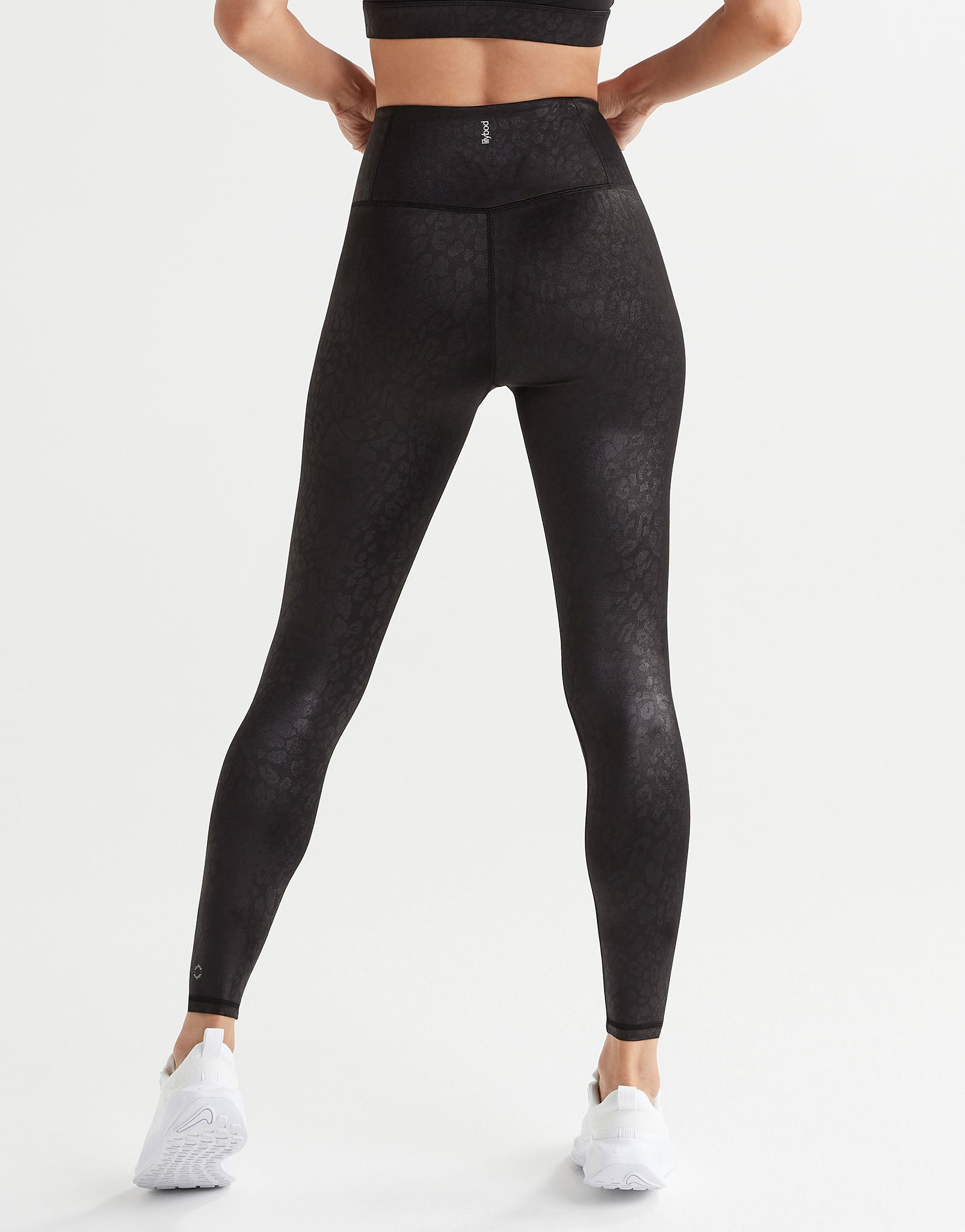 Person wearing black leggings on a white background