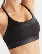 Black sports bra with animal print trim on a neutral background