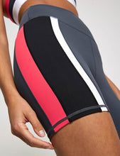 Athletic shorts with black, red, and white design on a neutral background