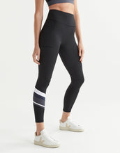Woman wearing black leggings with a white stripe on a light gray background