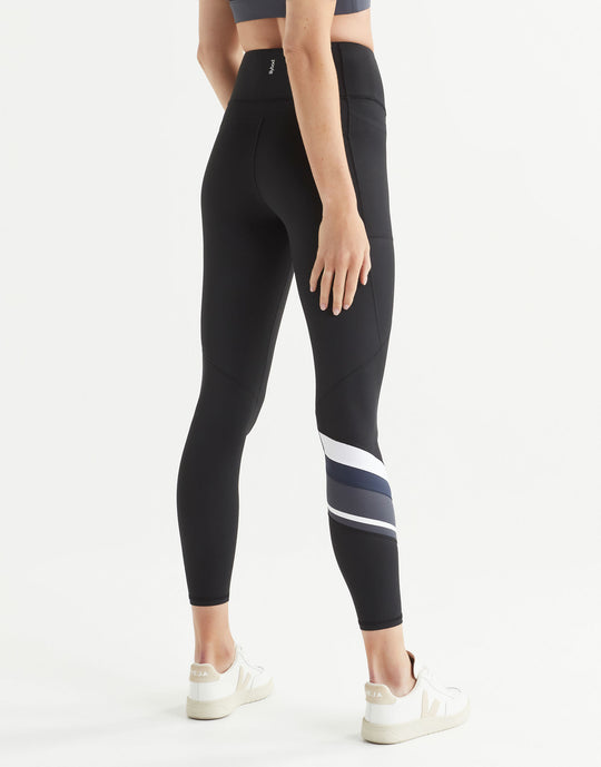 Black leggings with white and gray stripes worn by a woman on a white background