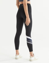 Black leggings with white and gray stripes worn by a woman on a white background