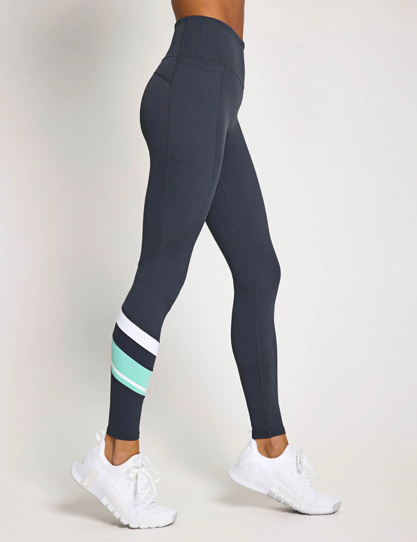 Dark gray leggings with white and green stripes on a white background