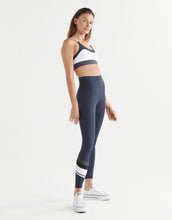 Woman wearing a sports bra and leggings on a white background