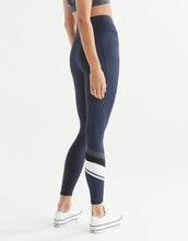 Navy blue leggings with white stripes worn by a person on a light gray background