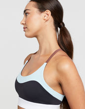 Woman wearing a sports bra with a gradient design on a plain background