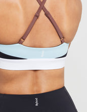 Close-up of a sports bra with criss-cross straps on a neutral background