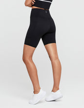 Person wearing black athletic shorts on a light gray background