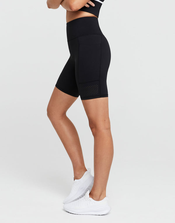 Person wearing black athletic shorts on a white background