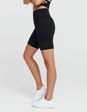 Person wearing black athletic shorts on a white background