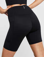 Black athletic shorts with a brand logo on a light gray background