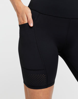 Black athletic shorts with a pocket on a light gray background