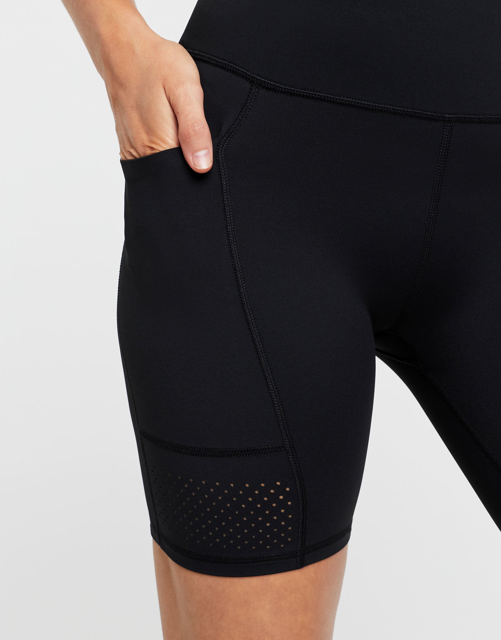 Black athletic shorts with a pocket on a light gray background