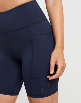 Navy blue athletic shorts with a pocket on a white background