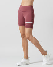 Person wearing maroon athletic shorts on a light gray background