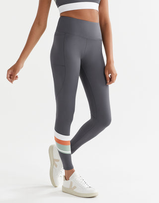 Person wearing gray leggings with colorful accents on a white background