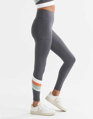 Gray leggings with colorful stripes on the legs worn by a person on a white background
