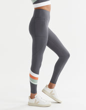 Gray leggings with colorful stripes on the legs worn by a person on a white background
