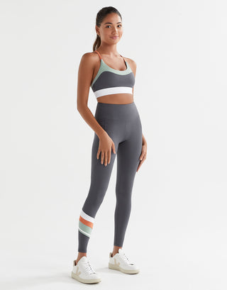 Woman wearing a sports bra and leggings set on a white background