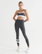Woman wearing a sports bra and leggings set on a white background