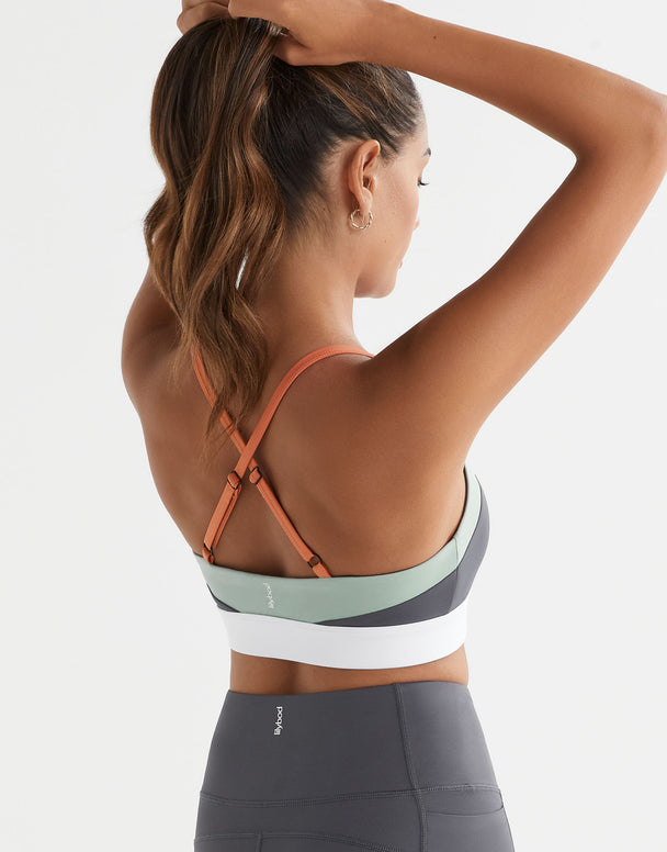 Woman wearing a sports bra and leggings on a white background