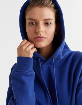 A woman wearing a blue hooded fleece sweater.