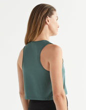 Woman wearing a green tank top on a white background
