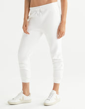 White jogger pants worn by a woman on a white background