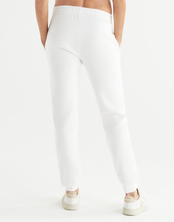 White jogger pants worn by a person on a white background