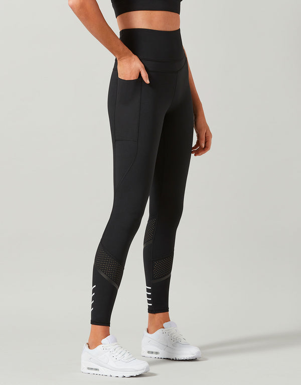 Black leggings with white accents worn by a person on a gray background