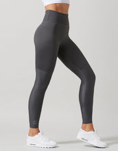 Dark gray leggings worn by a person on a light gray background