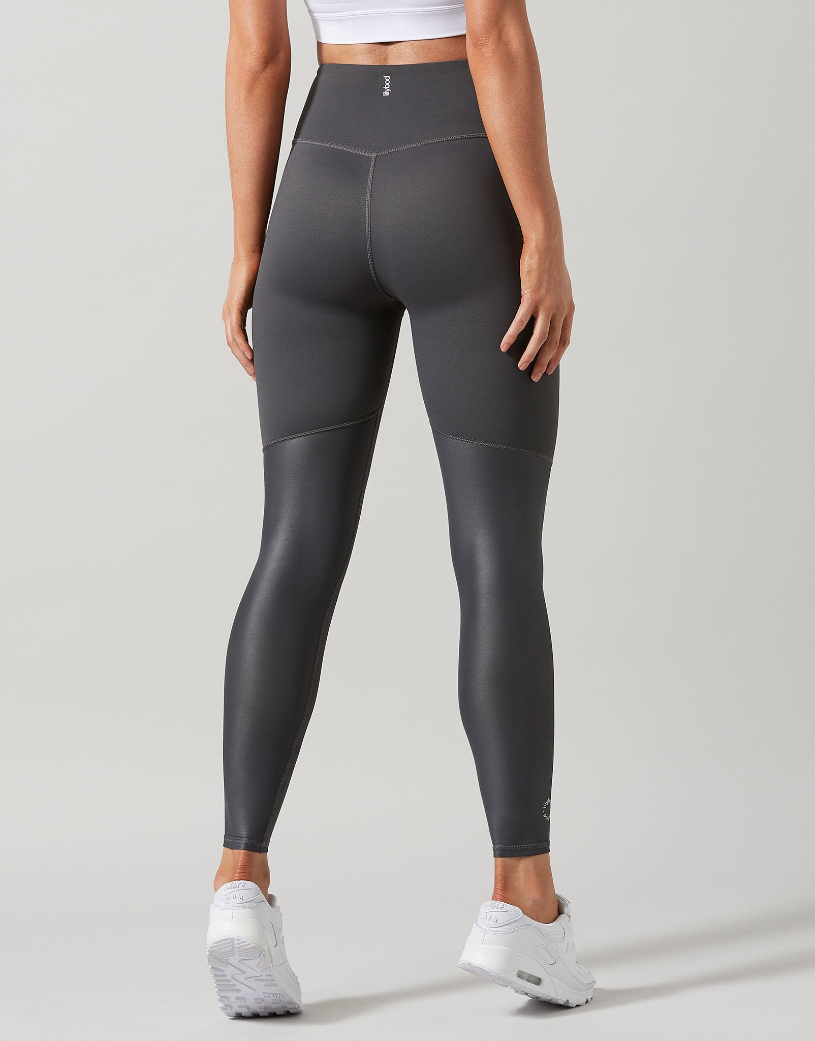 Person wearing gray leggings on a light gray background
