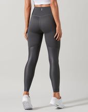 Person wearing gray leggings on a light gray background