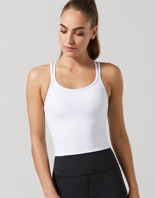 A model wearing a white Lilybod activewear top and black leggings.