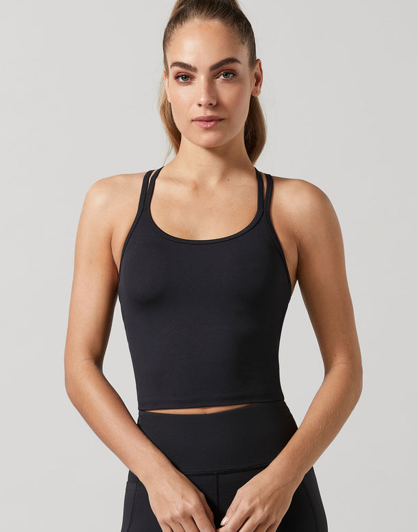 A woman wearing a black activewear top and leggings.