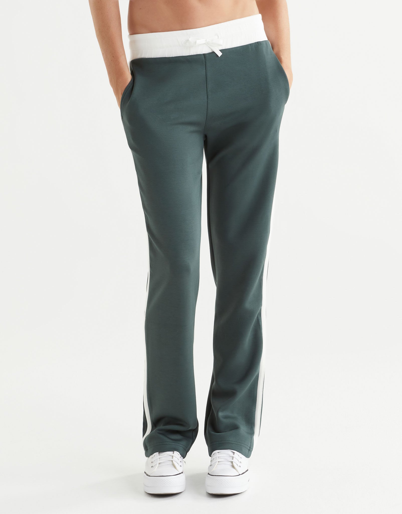 Green pants worn by a person on a white background