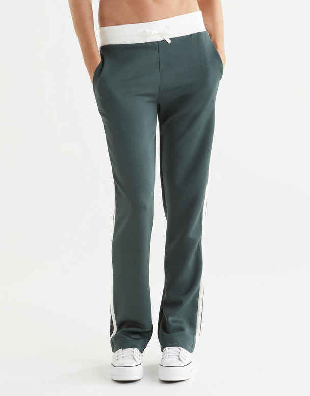 Green pants worn by a person on a white background