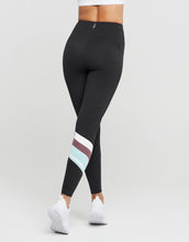 Black leggings with colorful stripes worn by a person on a white background