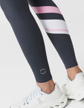 Navy leggings with pink and white stripes worn by a person on a light gray background