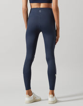 Navy blue leggings worn by a person on a light gray background