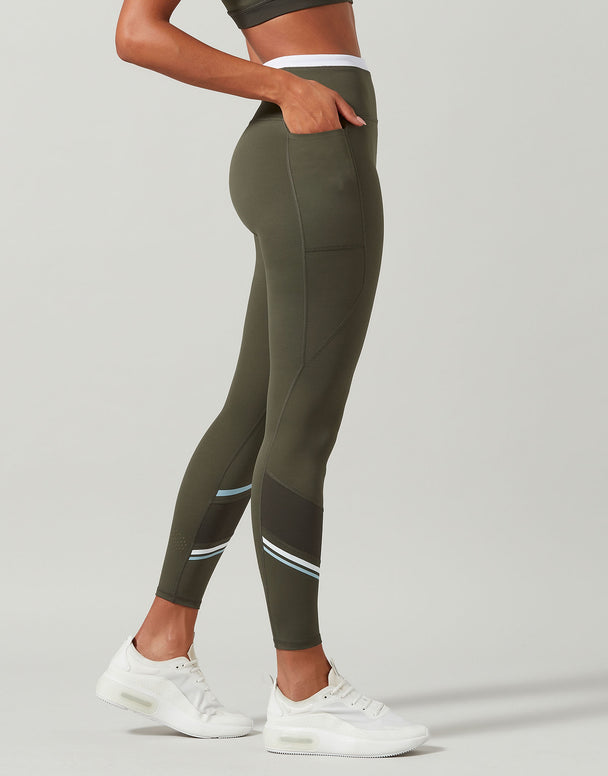 Person wearing green leggings with white accents on a gray background