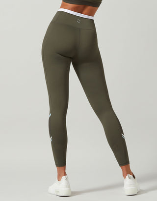 Olive green leggings worn by a person on a light gray background