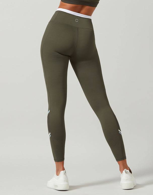 Olive green leggings worn by a person on a light gray background