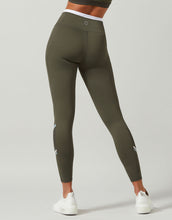 Olive green leggings worn by a person on a light gray background
