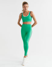 Woman wearing a green athletic outfit on a white background