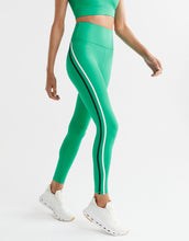 Green leggings with white stripes worn by a person on a white background