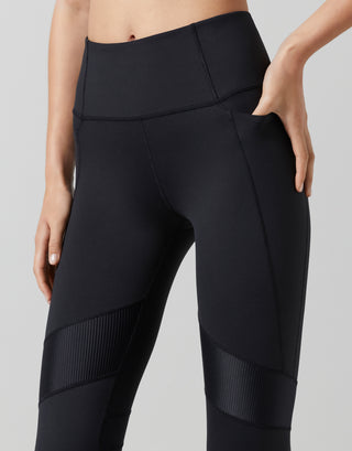 Black leggings with textured panels on a gray background