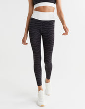 Person wearing black zebra-striped Lilybod leggings on a white background