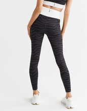 Person wearing black zebra-striped leggings on a white background